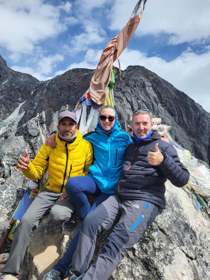 Trekkers posing with their mountain guide during Everest Base Camp trek in the Himalayas