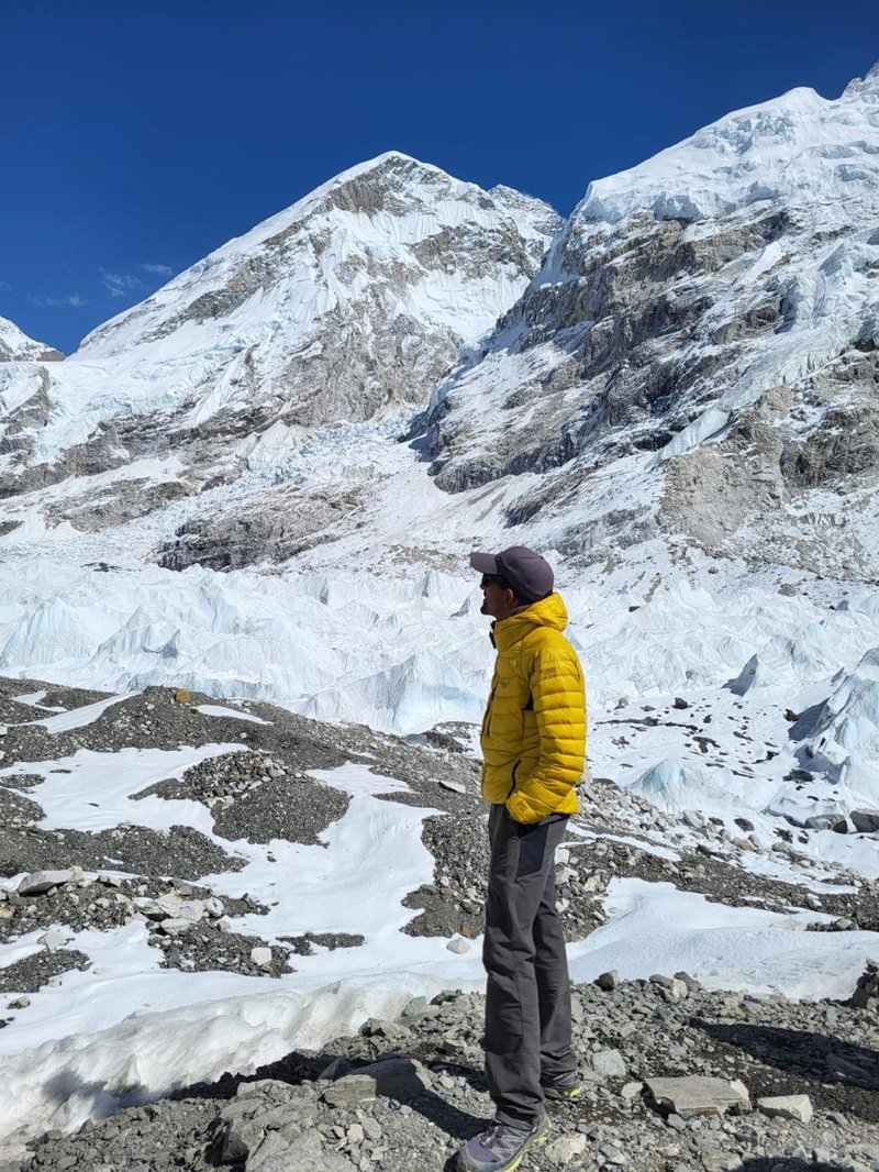 Happy trekkers celebrating at Everest Base Camp with mountain backdrop