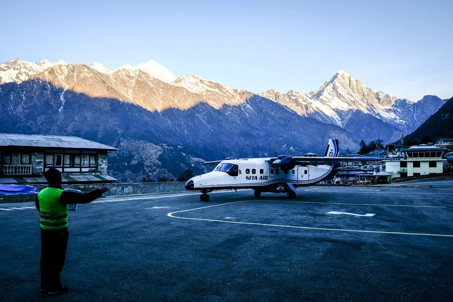 Airplane landed at Lukla Airport with Himalayan peaks in the background, starting point for Everest Base Camp treks